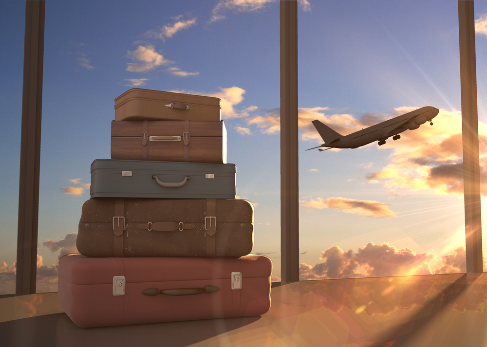 A plane takes off with visible luggage in the foreground. 